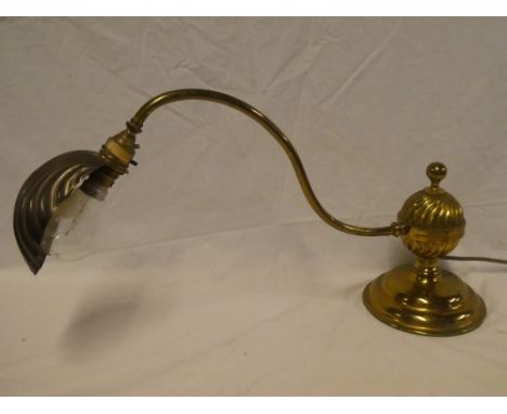 An old brass piano/desk lamp with scallop-shaped cover