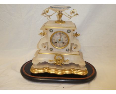 A 19th Century French gilt mounted marble mantel clock with circular dial in ornamental tapered case and urn finial on ebonis