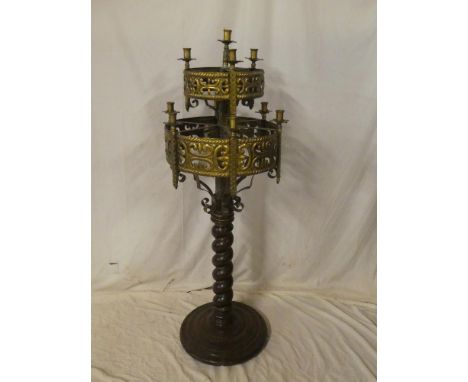 An unusual brass and iron ecclesiastical-style candle lamp standard with ten sconces, pierced decoration on spiral twist maho