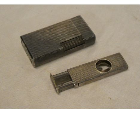 A small silver rectangular cigar cutter with engine turned decoration, Birmingham marks and a silver plated lighter by Dunhil