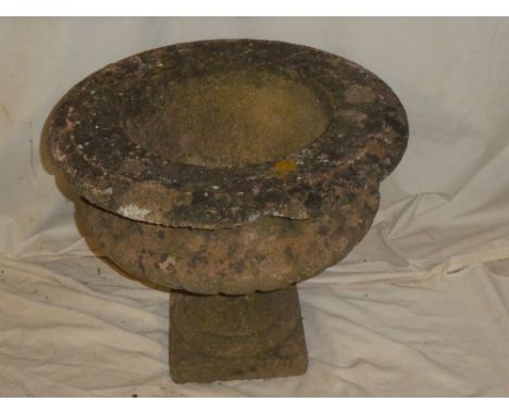An old weathered composition pedestal garden urn, 17½" diameter