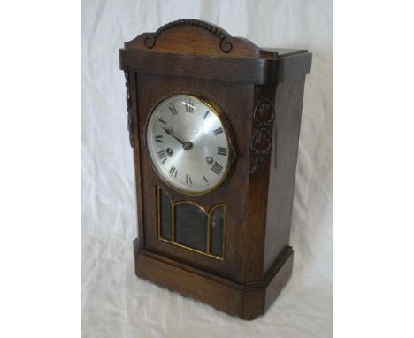 A 1920/30s mantel clock with silvered circular dial in oak glazed case