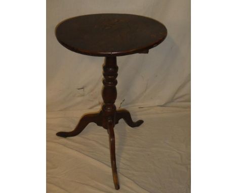 An 18th Century oak and elm circular snap top occasional table on turned column with tripod base