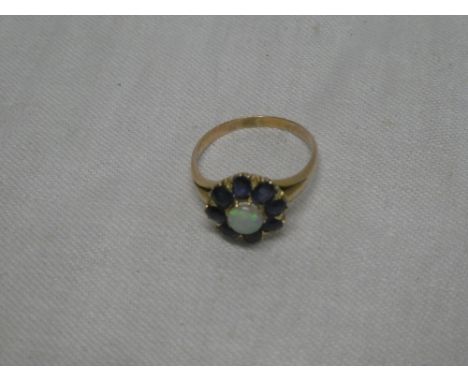 A 9ct gold dress ring set an opal surrounded by sapphires