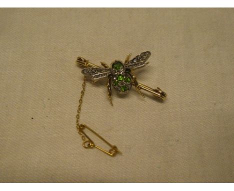 A good quality gold bar brooch in the form of a bee with peridot mounted body, diamond encrusted wings and opal eyes