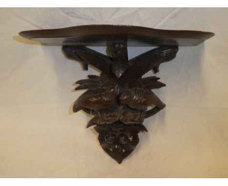 A Continental polished and carved wood wall bracket, the stem modelled as two small birds amid foliage