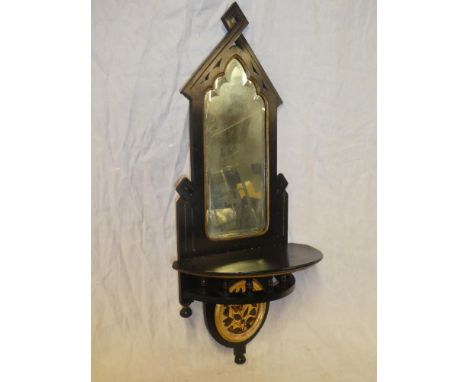 A late Victorian ebonised and gilt painted arched wall mirror with semi-circular shelf and butterfly decorated panel