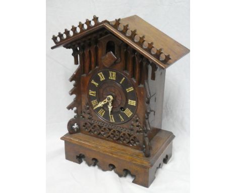 An old Continental cuckoo bracket clock with decorated circular dial in carved oak traditional case, 17" high