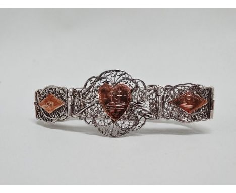 An early 20th century white metal filigree bangle - the foliate panels incorporating yellow metal lozenges showing Middle Eas