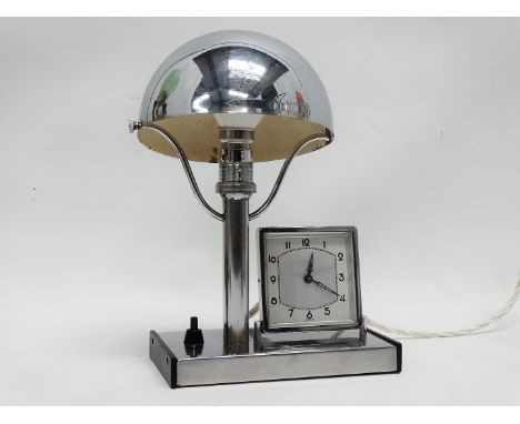 An Art Deco chrome bedside lamp - the base incorporating a timepiece, with a dome chrome shade.