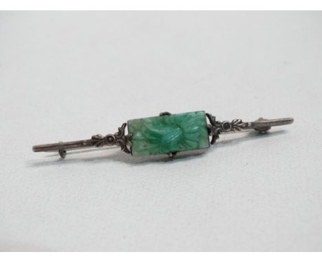 A jade brooch - the central rectangular panel carved as a chrysanthemum, set in white metal stamped silver, weight 4g.