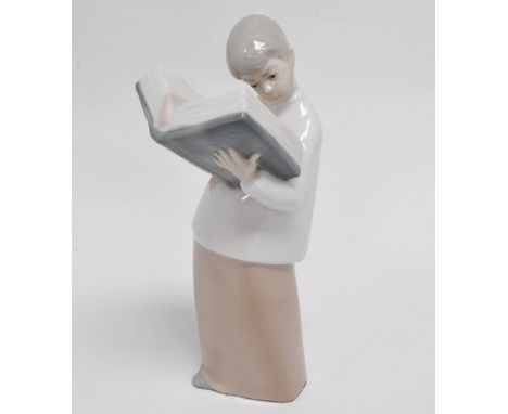 A Nao style figure - reading from a large tome, height 20cm.