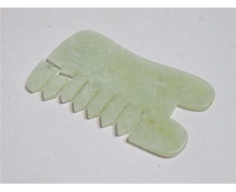 A Chinese green jade comb - rectangular to lobed ends and corse teeth, width 9cm.