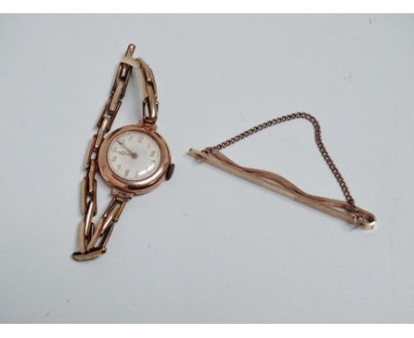 A 9ct gold baton tie clip - engraved with chevron pattern, weight 7.5g, together with a 9ct gold cased ladies wristwatch.