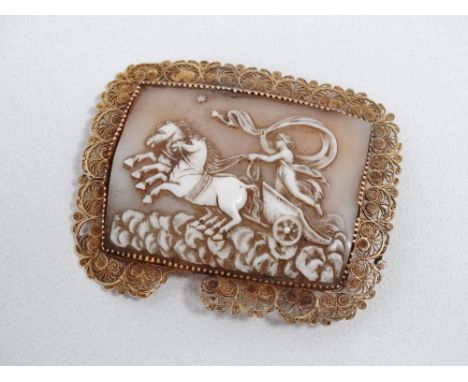 A yellow metal filigree cameo brooch - the panel depicting a charioteer following a star, length 6cm. 