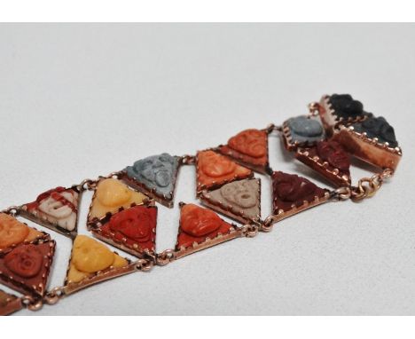 A 19th century lava panel bracelet - comprising thirty three triangular panels carved with comical faces set in yellow metal,