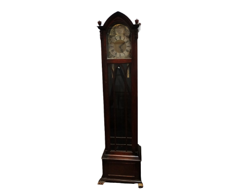 A 20th century oak longcase clock - the silvered chapter ring set out with Roman numerals, flanked by masked spandrels, the l