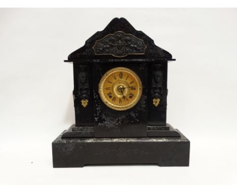 A late Victorian black slate mantel clock - with green marble details, Egyptian masks and cherubs the brassed dial set out in