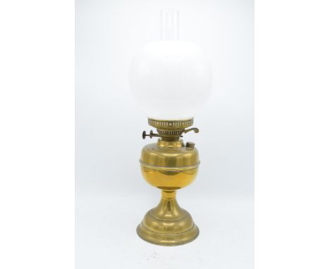 An early 20th century brass oil lamp with associated chimney and shade. 28cm tall without shade. 