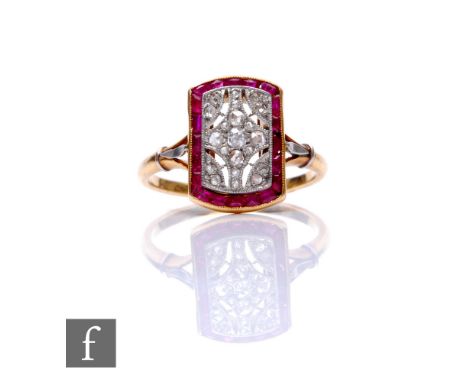 An 18ct ruby and diamond cushioned rectangular ring central pierced pave set diamond panel within a border of baguette cut ru
