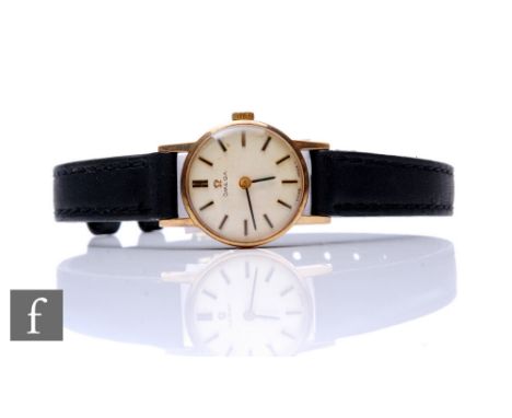 A lady's 9ct Omega manual wind wrist watch, batons to a circular dial, case diameter 18mm, all to a leather strap. 