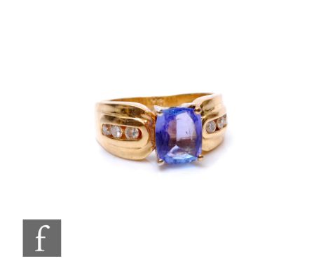 A 14ct tanzanite and diamond ring, central cushioned emerald cut tanzanite, length 8mm, flanked by three channel set diamonds