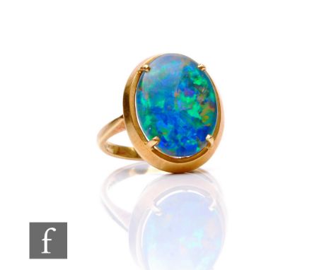 A 14ct single stone opal doublet ring, oval claw set stone to knife edged shoulders, weight 6.2g, ring size M. 