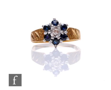 An 18ct sapphire and diamond cluster ring, central diamond within a six stone sapphire border, weight 3g, ring size P. 
