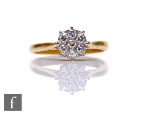 An 18ct hallmarked diamond cluster ring, seven stones claw set to a circular head and knife edged shoulders, weight 3g, ring 