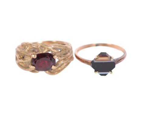 A brutalist design 9ct gold and garnet set signet ring, size P, and a 9ct and agate set signet ring, size Q, 8.1g gross 