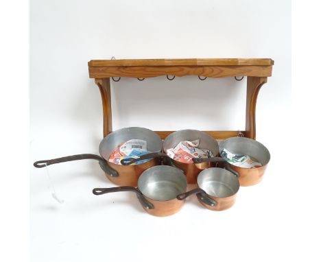 A graduated set of 5 Vintage French copper saucepans, largest diameter 21cm, with associated pine wooden bracket
