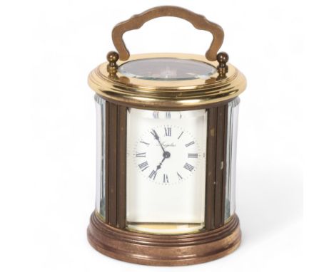 A French brass oval carriage clock, white enamel dial and Roman numerals, dial marked Angelus, height not including handle 8c