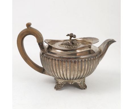 A Georgian silver tea pot, with flower finial, gadrooned body and raised on four embossed feet, London 1804, weight 25oz all 