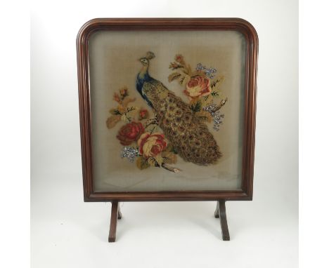A 19th century framed wool work fire screen, decorated with a peacock and roses with bead work foliage, width 22ins