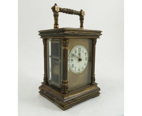 A brass cased striking carriage clock, with white enamel dial set in a gilt panel, with fluted columns, height including hand