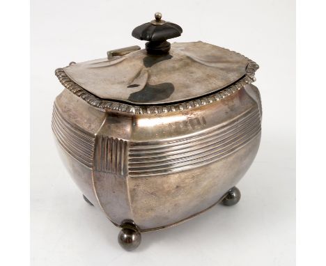 A silver tea caddy, of shaped rectangular form, having a gadrooned rim, ribbed band and raised on ball feet, Sheffield 1909, 