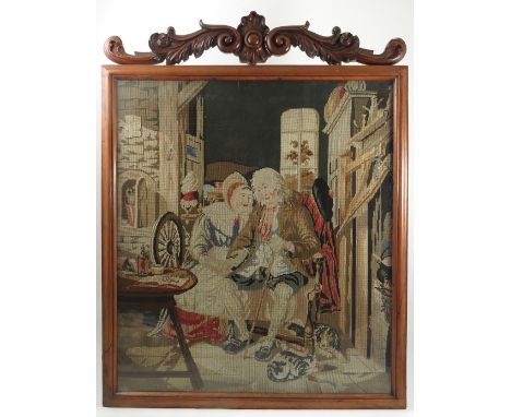 A 19th century rosewood framed tapestry picture, interior scene with elderly couple seated, the frame with carved scroll and 