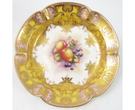 A Royal Worcester circular shaped dish, decorated to the centre with a panel of hand painted fruit, by R Lewis, to a shaped y