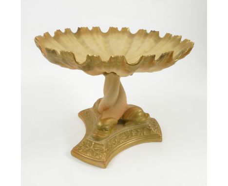 A Royal Worcester blush ivory tazza, the shell plate supported on three dolphin supports to a triform base, dated 1912, diame