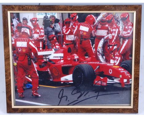 Formula 1, a collection of items to include a colour photograph of Michael Schumacher in Ferrari pit, bears signature in blac