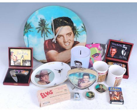 A collection of Elvis Presley memorabilia, to include a wall clock, alarm clock, money box, mugs, coasters and VHS cassettes 