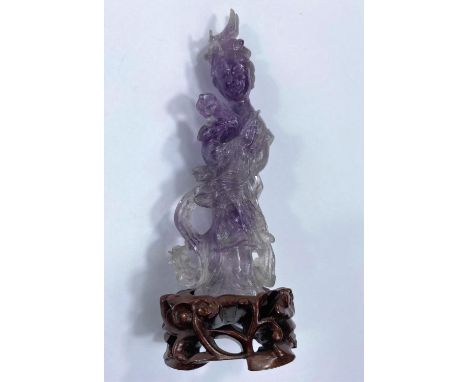 A Chinese amethyst carved figure of a woman with flowers, on hardwood base, height overall 12cm.&nbsp;&nbsp;Some minor chips 