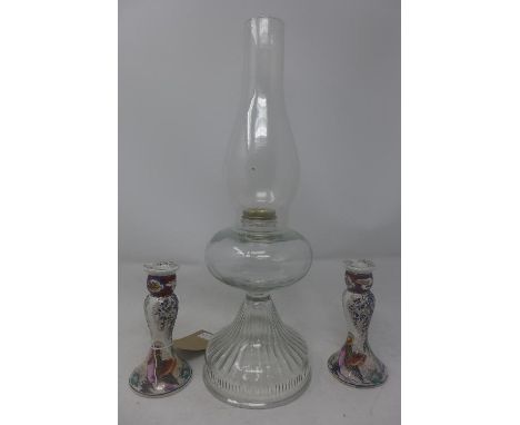 A glass oil lamp, with globular bowl on spreading foot (no burner), H.48cm, together with a pair of porcelain candlesticks, p