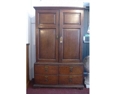 An early 19th century oak housekeepers cupboard, with two doors enclosing adjustable shelves, above four drawers raised on br