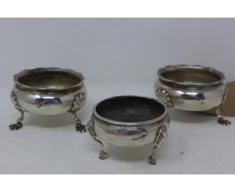 A pair of George II silver salts, London 1756, on three paw feet, H.4.5cm Diameter 8cm, together with a Georgian silver salt,