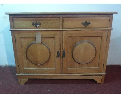A 'this and that' light oak sideboard, with two drawers over two cupboard doors raised on bracket feet, H.94 W.122 D.55cm 