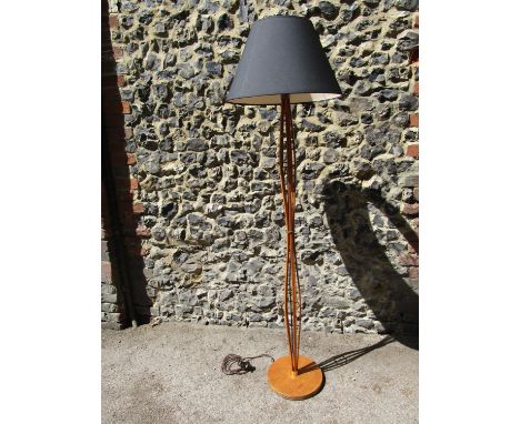 A mid 20th century teak standard lamp, consisting of five strips of wood bent into an hour glass shape, united by three brass