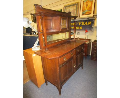 An oak Arts and Crafts sideboard circa 1900, retailed by Liberty in 1997, the mirrored back with glazed cupboard and open she