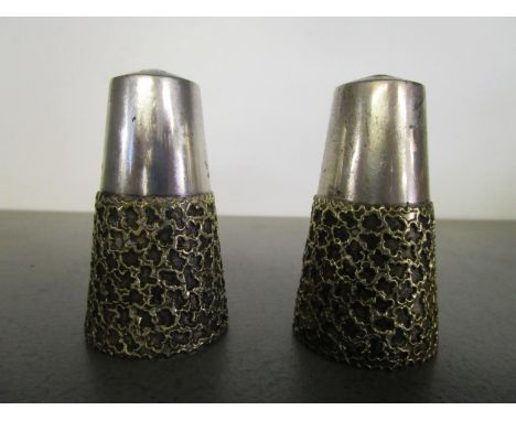 Stuart Devlin 1931-2018 - a pair of silver and silver gilt salt and pepper pots with applied cage work over a textured ground