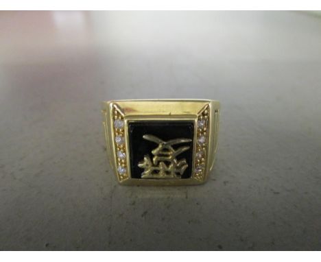 A 925 silver gilt Chinese college style ring with black enamel plaque top with a calligraphy character, flanked by four white